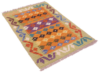 A rectangular woven kilim rug with a multicolor geometric pattern, featuring orange, purple, blue, brown, and cream motifs on a beige background with fringed edges.