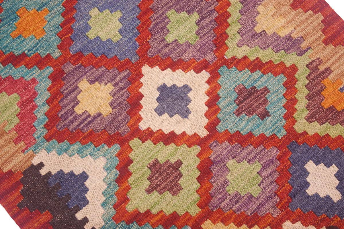 Close-up kilim rug with multicolor star and diamond motifs on textured woven field