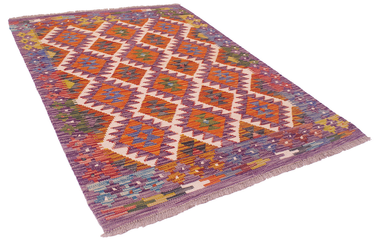 Purple and orange kilim rug, angled view, geometric diamonds with flat woven weave.