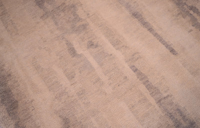 Close up detail of modren abstraxt handknotted Indian Carpet with gentle neutral tonalies of cream-beige ground and soft fluid greys.