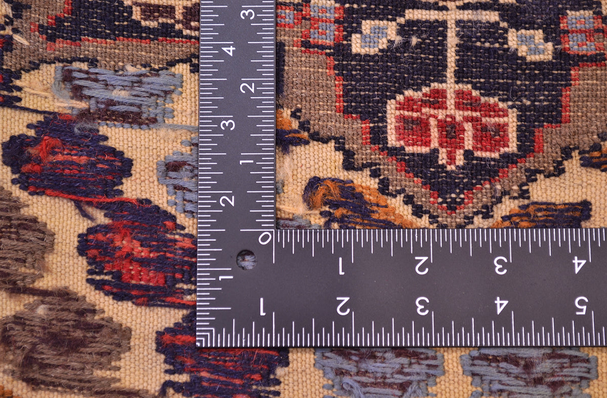 Close-up of a patterned handwoven Afghan Barjasta Rug with a dark L-square ruler placed over it to show scale/fineness of the weave, showing a beige, navy, red, and grey woven design.