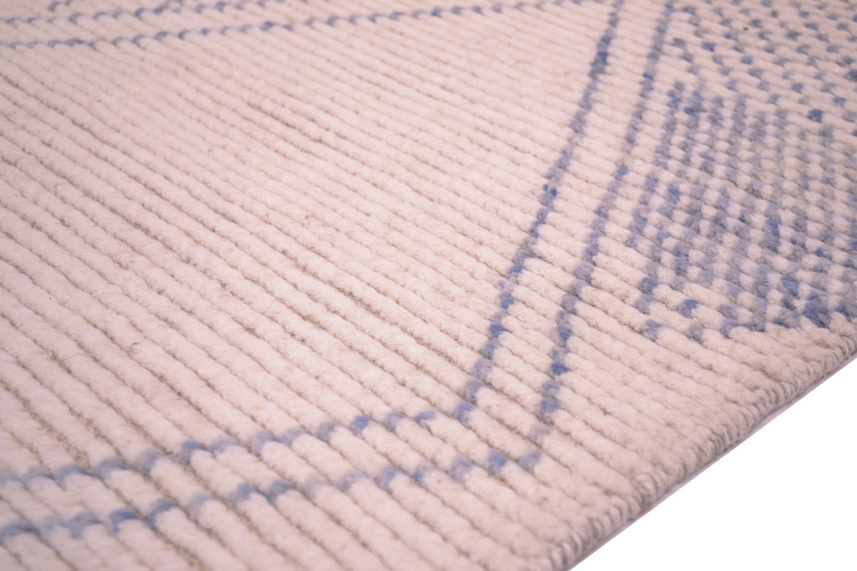 Close-up of a textured Afghan Berber style runner rug with a ribbed texture in cream and light blue, showing the corner detail and woven texture.