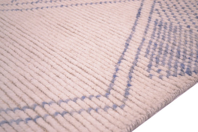 Close-up of a textured Afghan Berber style runner rug with a ribbed texture in cream and light blue, showing the corner detail and woven texture.