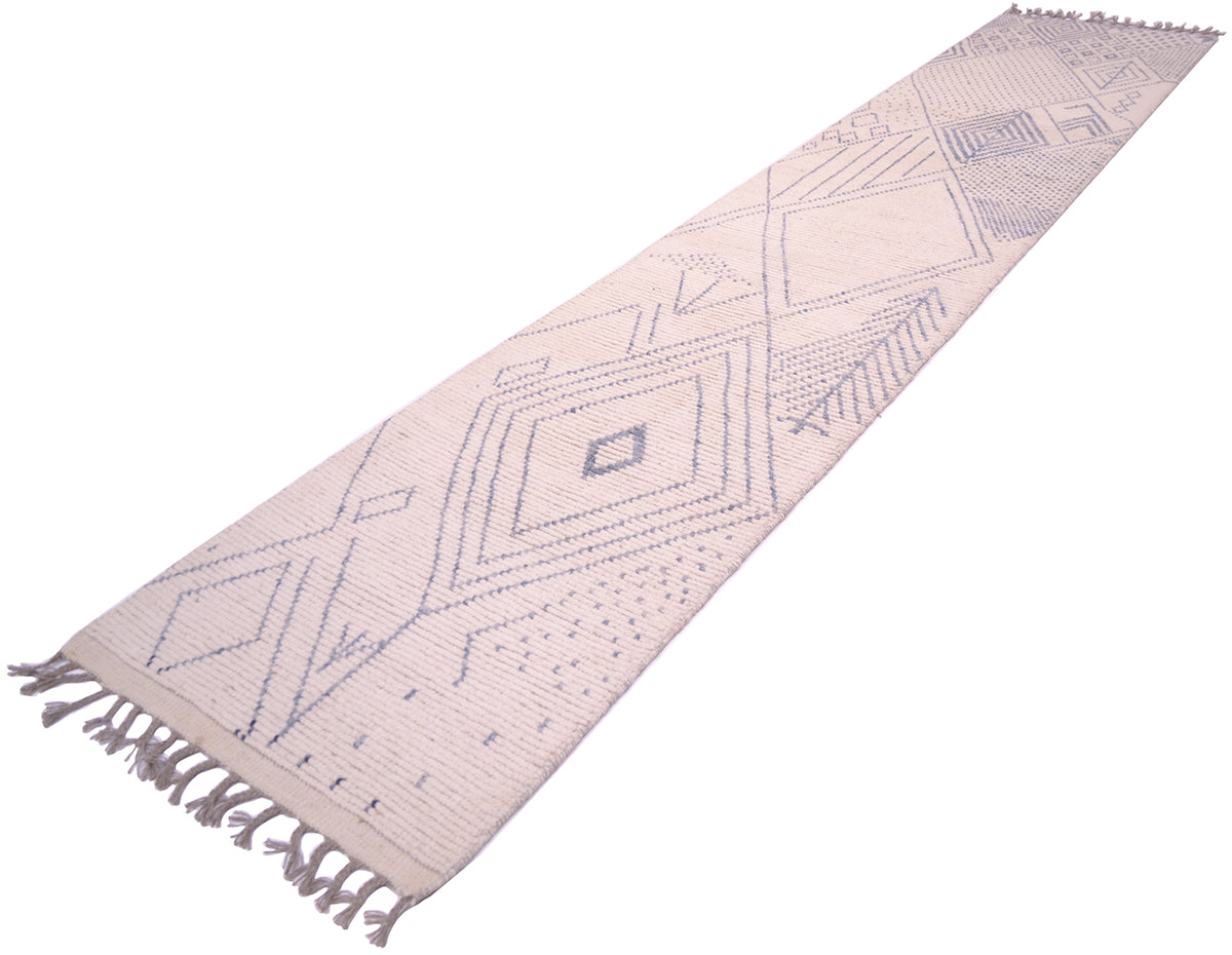 A long woven Afghan Berber style runner rug with a geometric diamond pattern in muted blue-grey on a warm off-white background, featuring fringed ends.