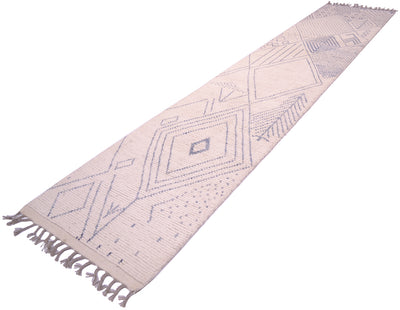 A long woven Afghan Berber style runner rug with a geometric diamond pattern in muted blue-grey on a warm off-white background, featuring fringed ends.