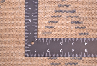 Close-up of a handwoven Afghan Berber design runner texture in beige and brown tones with grey-blue accents, shown with a metal L-square ruler for scale of the weave.