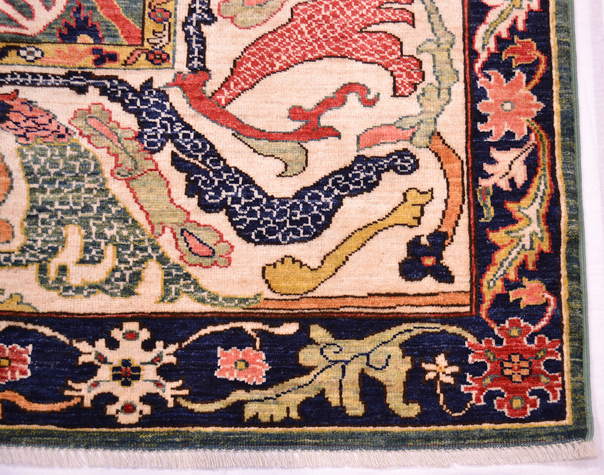 Corner detail of main border and outer border of antique style carpet with cream and midnight blue background.