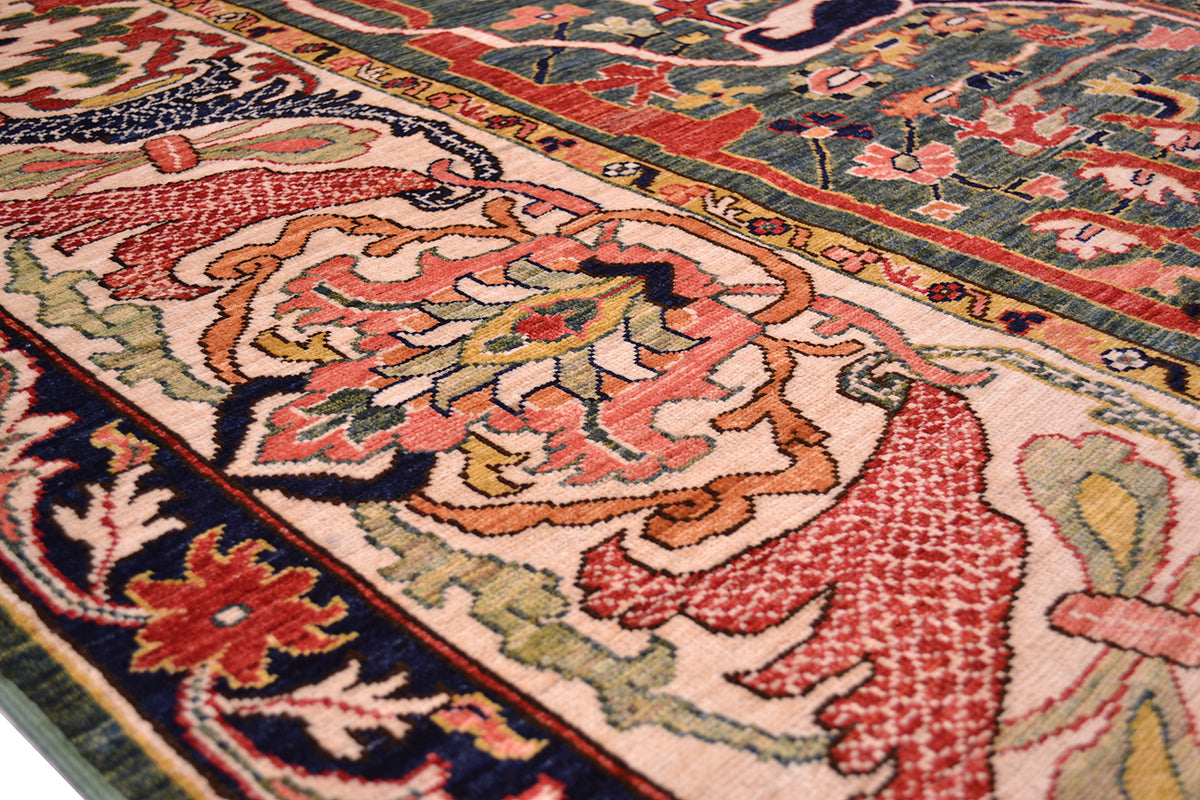 Close up detail of main wide border of handmade carpet with cream background and large floral palmette. Outer border with rich midnight blue base colour.