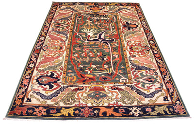 Rich tonalities and expanisive design of antique style carpet in multiple colours  of green, dark blue, cream, gold terracotta and coral pinks.