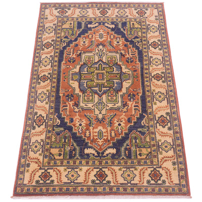 A traditional oriental-style heriz area rug with a complex geometric medallion pattern in navy blue, rust orange, beige, and green, shown flat against a white background.