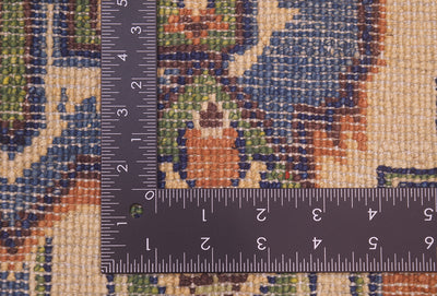 Close-up of the hand-knotted back of an Afghan Heriz design handmade rug with a dark metal ruler showing measurements in centimetres and inches to help show scale.