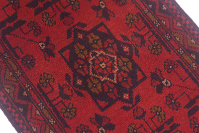 Close-up of red rug runner with geometric motifs and multicolor accents