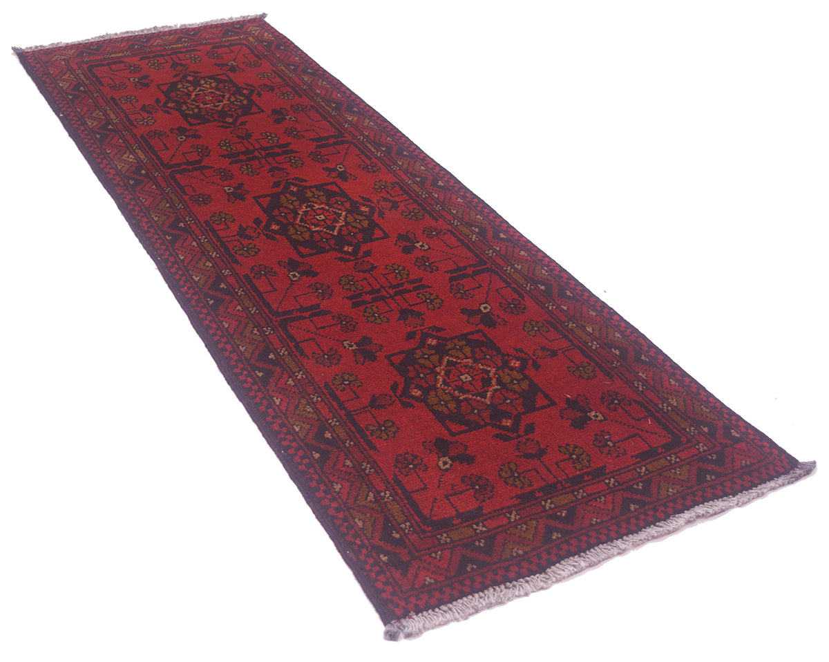 Red patterned rug runner laid flat, showcasing ornate geometric design