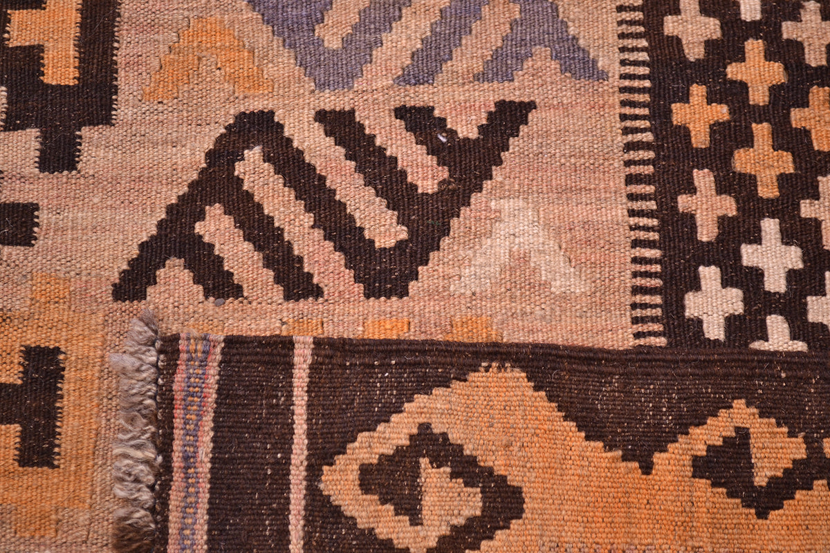 Close-up of the weave of a handwoven large old Afghan Kilim rug with geometric patterns in dark brown, terracotta orange, beige, and muted lavender-grey.
