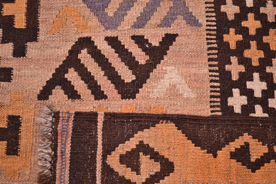 Close-up of the weave of a handwoven large old Afghan Kilim rug with geometric patterns in dark brown, terracotta orange, beige, and muted lavender-grey.