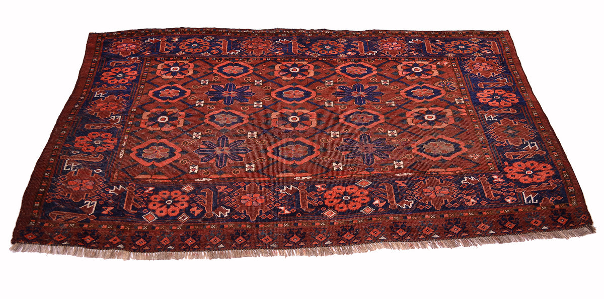A traditional antique Turkoman Ersari Beshir style Chuval or rug with a complex geometric and floral pattern in dark red, navy blue, and rust orange, featuring a fringed edge on a white background.