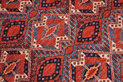A close-up of a handwoven Fine antique style Beshir rug with a geometric pattern in rust red, navy blue, beige, and muted blue.