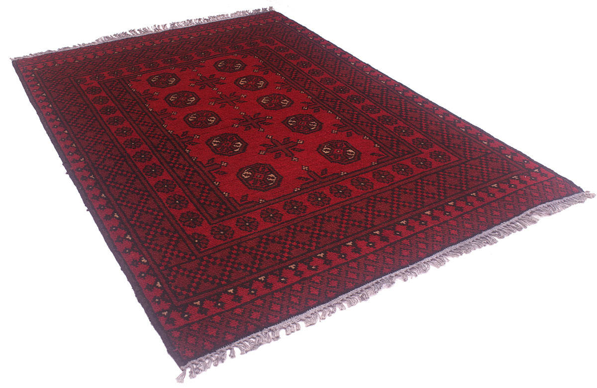A red and black patterned Afghan rug with fringed edges, shown from an elevated angle on a white background.