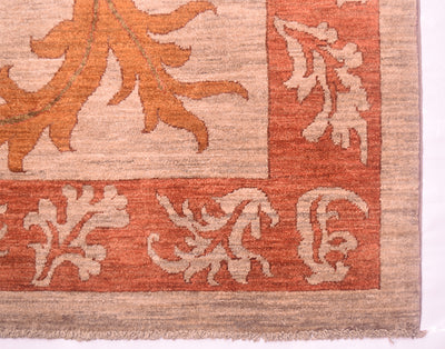 Corner of autunnal coloured handmade carpet with multiple leaf border in terracotta and grey-beige hues.