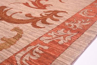 Detail of border leaf design with multiple leaves of handknotted carpet with leaf border with terracotta coloured border background and rich chestnut brown outlining design for definition.