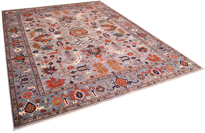 Angled view of impressive handmade carpet with Antique Persian Serapi design with modern colours with neutral grey field with bluish border with all over floral geometric design with orange, golden ochre tones, teal, blue and ligth mauve accents.  Highlights of light cream in border and main field.