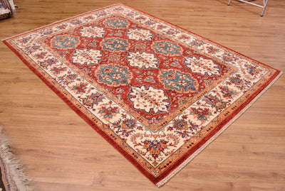 A traditional oriental Afghan Bakhtiar area rug with a red field, beige floral motifs, and blue accents, displayed on a light wood floor.
