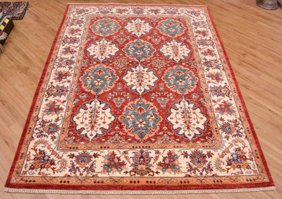 A traditional Persian-style Bakhtiar area rug with a red, beige, and blue floral pattern, laid out on a light wood floor.