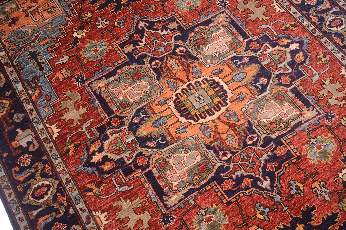 Close-up of rug weave with red, orange, blue and beige geometric motifs