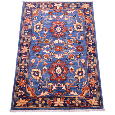 A rectangular traditional blue Aryana rug with a blue field, featuring a central floral medallion and ornate borders in rust red, beige, and cream, shown flat against a white background.
