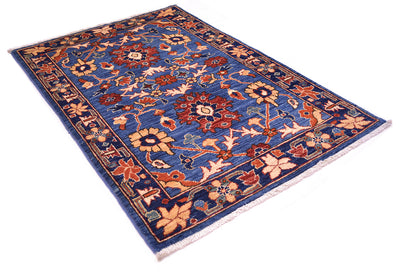 A traditional Persian-style Afghan small rug with a deep blue field, featuring intricate floral motifs in rust red, beige, and orange, framed by a matching patterned border with white fringe.