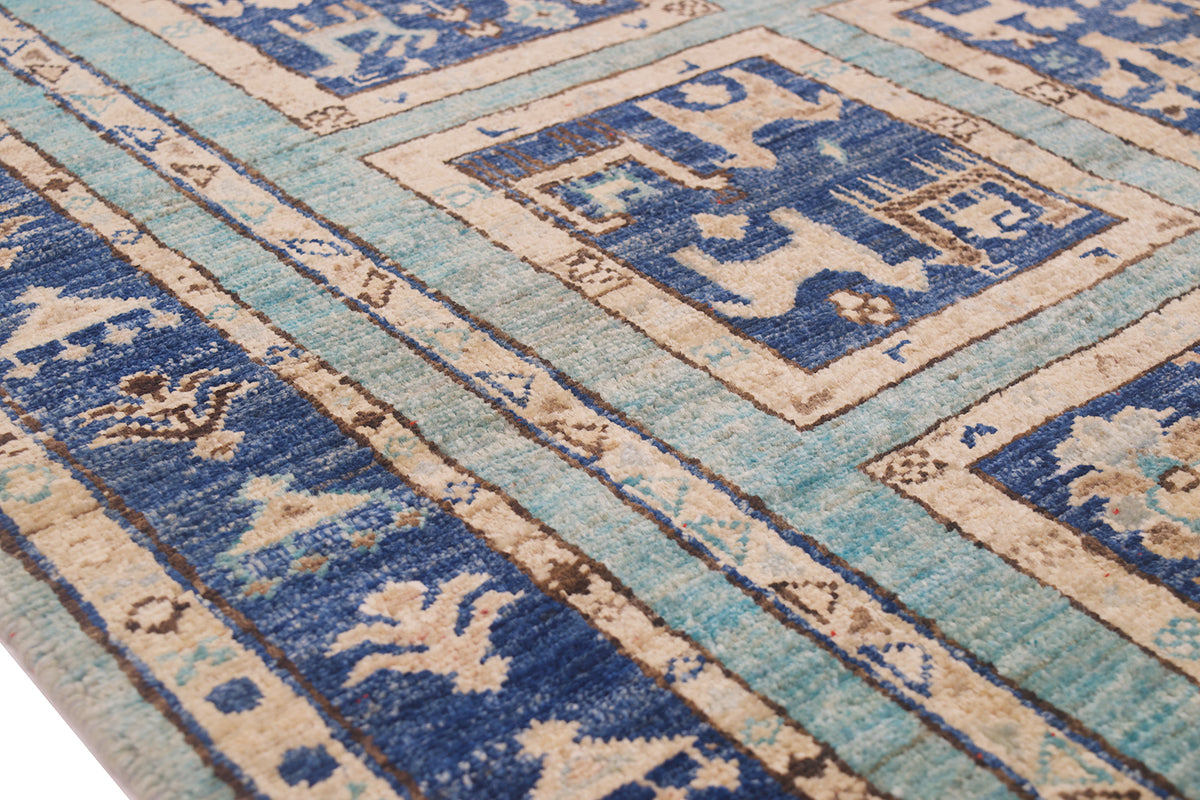 A close-up of a patterned hand-knotted Afghan small rug with a traditional geometric design in shades of blue, beige, and light aqua.