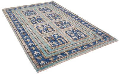A 1.50x1.00m rectangular Afghan Aryana area rug with a traditional geometric and floral pattern in shades of blue, beige, and light teal, shown from an elevated angle on a white background.