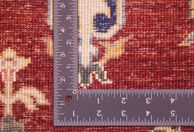 Close-up of a patterned hand-knotted Pictorial fine Aryana Carpet with a dark measuring ruler placed vertically and horizontally to show scale of the knotting, highlighting the texture and dimensions of the red and beige rug.