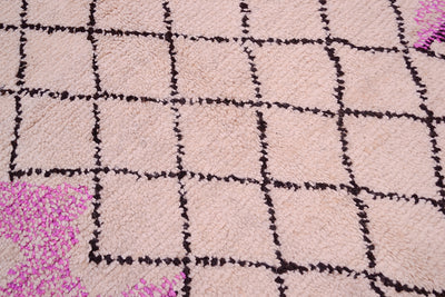 Close-up of Azilal rug texture: light pink pile with black grid lines and magenta accents.