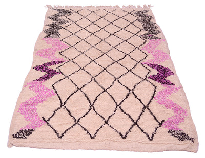 Vintage Azilal rug with symmetric black diamond pattern, magenta border accents, fringed edges.