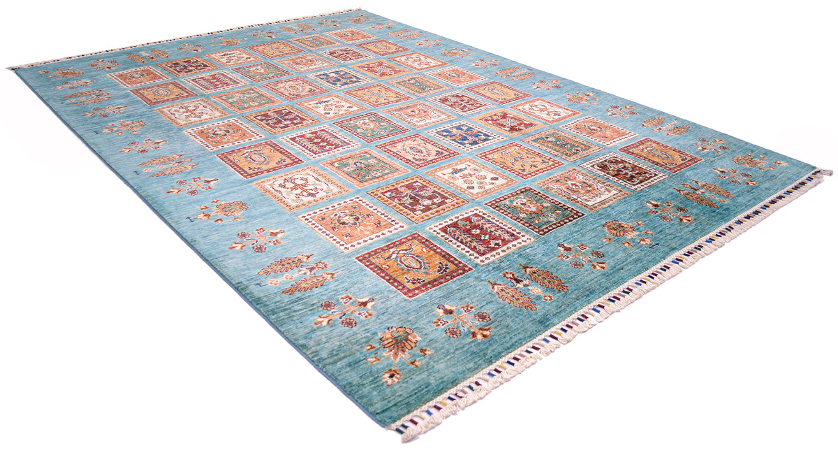 A rectangular Bakhtiari design turquoise carpet with a light turquoise field and a grid of multicoloured geometric and floral motifs, finished with a fringed edge, shown on a plain white background.