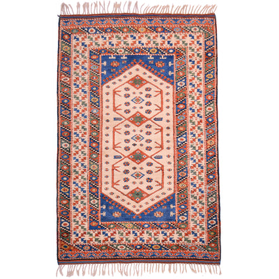 Old Turkish rug, cream with geometric design with detail colours in blue, orange/rust, and green.