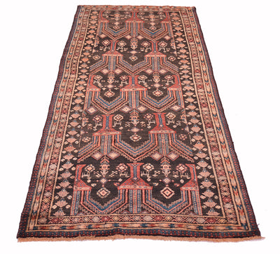 A traditional rectangular old Belouch wide runner rug with a dark charcoal field, featuring geometric patterns in red, beige, and teal, bordered by intricate geometric designs.
