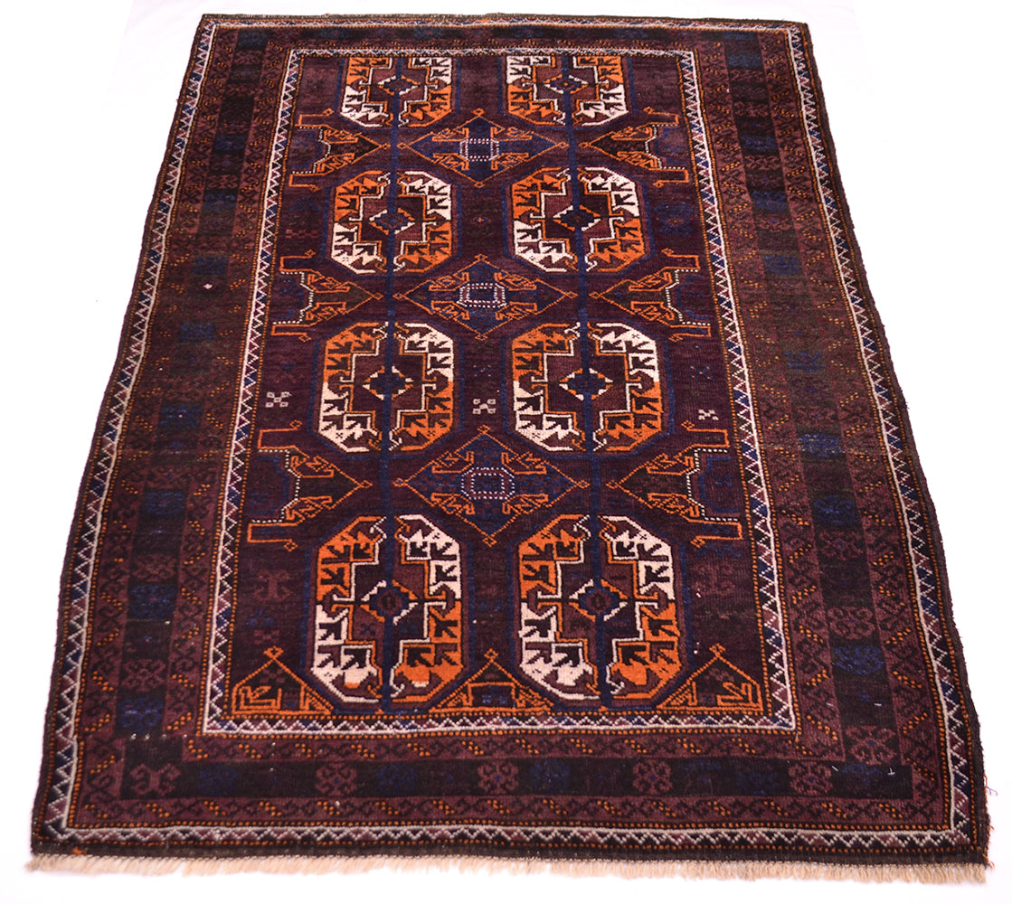 A traditional Oriental-style old tribal Baluchi wool rug with a dark brown field, featuring geometric motifs in rust orange, beige, and brown, finished with a patterned border and fringed edges.