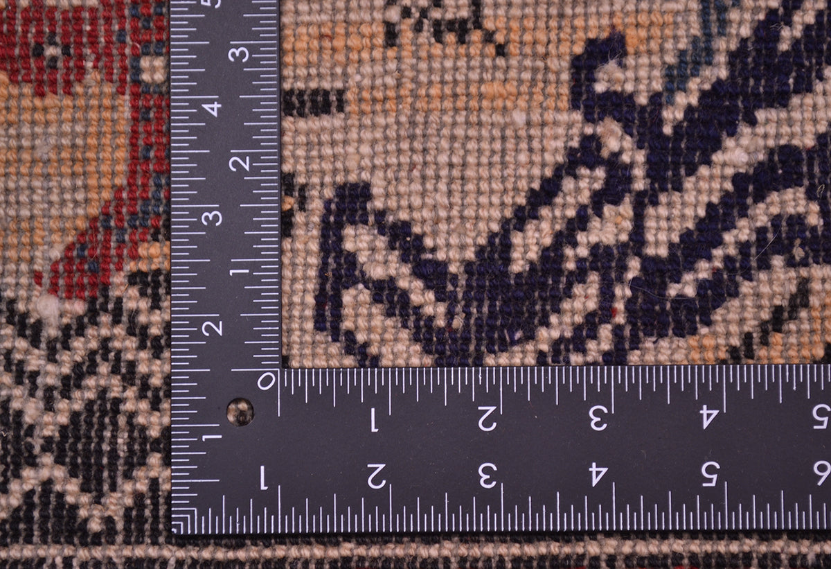 Close-up of a patterned Pictorial Afghan Belouch rug with a dark measuring ruler placed along the corner to show the size and weave detail.