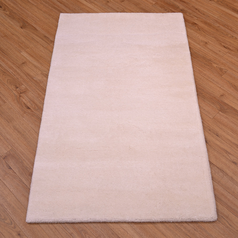 A rectangular off-white royal bengal Indian runner rug laid flat on a brown wooden floor.
