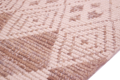 A close-up of a textured woven rug/runner with a geometric diamond pattern in shades of beige, tan, and light brown.