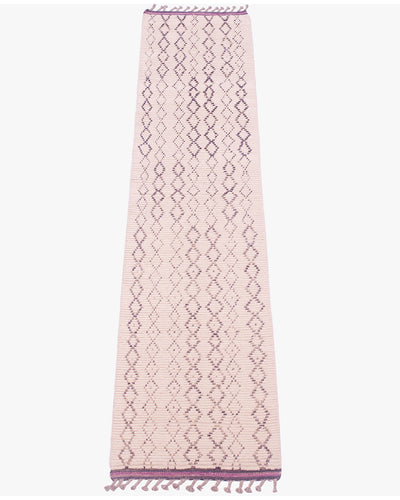 A long, narrow woven runner rug in cream with a repeating charcoal geometric diamond pattern and purple kilim ends with fringe at both ends, shown flat against a light gray background.