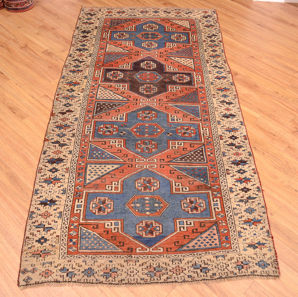 Antique Bergama rug with central octagon design, rust and blue accents, cream border