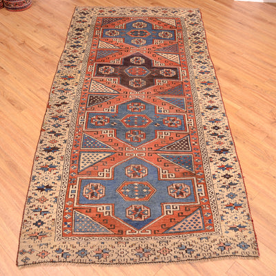 Antique Bergama rug with central octagon design, rust and blue accents, cream border