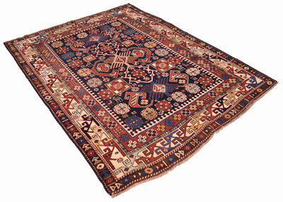 Antique rug laid diagonally; navy blue, red, and cream geometric border with central motifs.