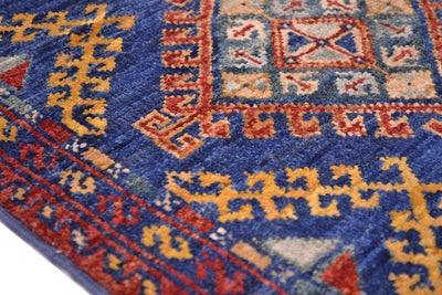 Close-up of a patterned Afghan Chobi strip with a deep blue field, red and orange geometric borders, and yellow motifs.