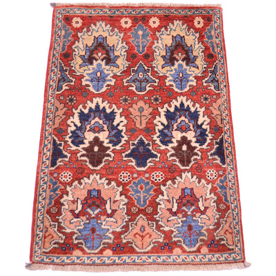 A traditional oriental Afghan Chobi Mat with a rusty-red field, featuring large central medallions in blue, beige, and brown, and a patterned border.