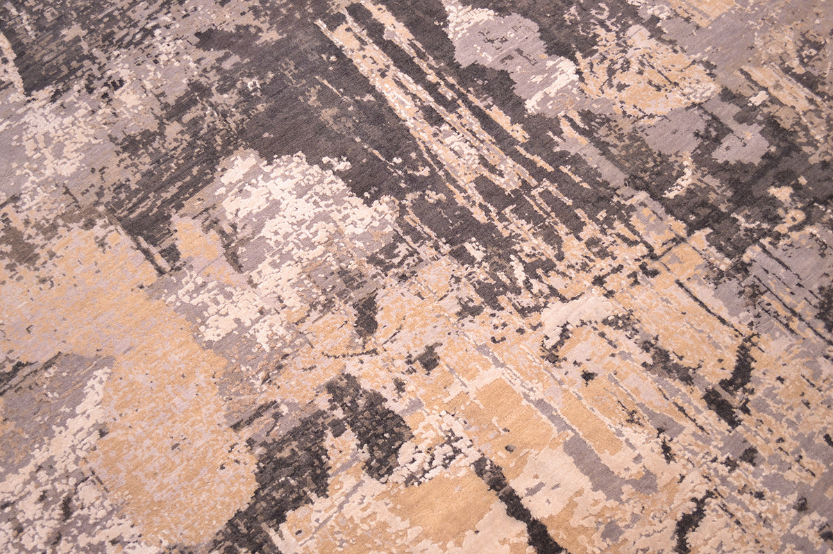 Close up view of handmade carpet with wool and silk pile with large areas of ivory cream silk highlights and textured surface with light to mid grey matte wool pile and taupe to mid brown matte wool pile.