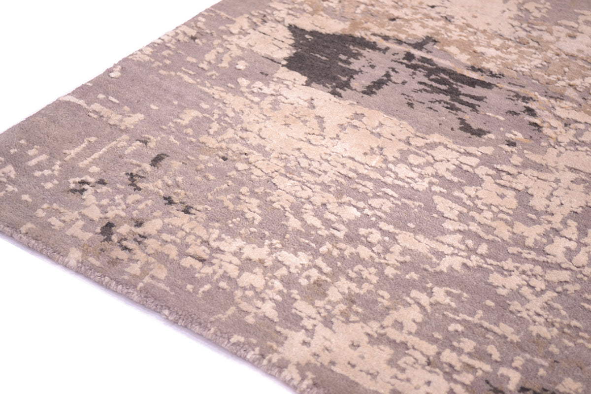 Detail of hadnwoven Indian Carpet with abstract design and charcoal grey wool  field and ivory light cream pure silk raised highlights.